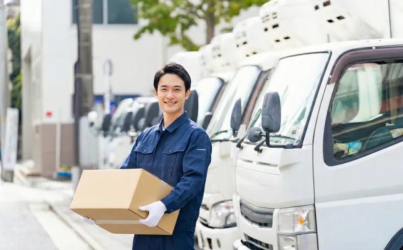 荷物を運ぶ新人トラックドライバー